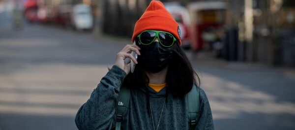 Девушка в маске и очках на пустынной улице Пекина  - Sputnik Латвия