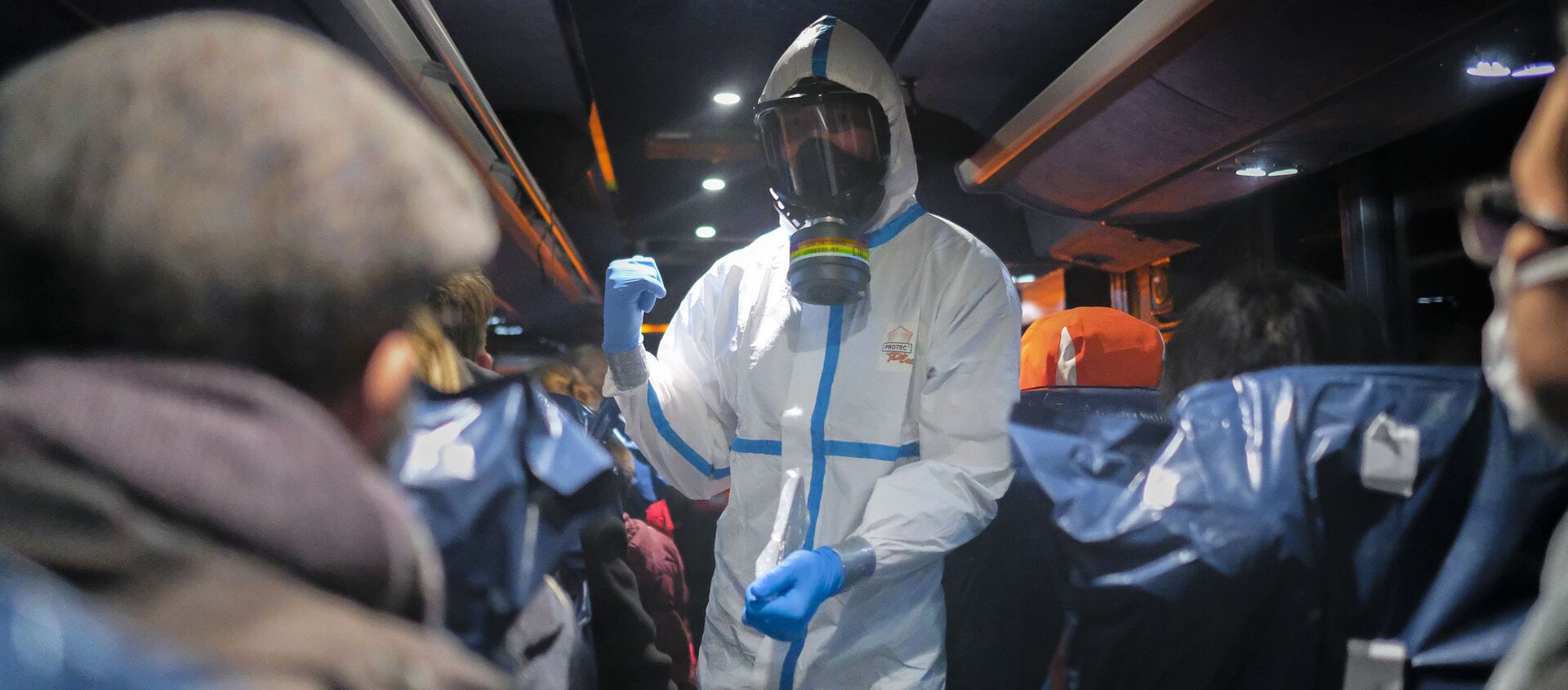 Офицер в защитной одежде инструктирует эвакуированных из Ухани, Китай - Sputnik Латвия, 1920, 04.02.2021