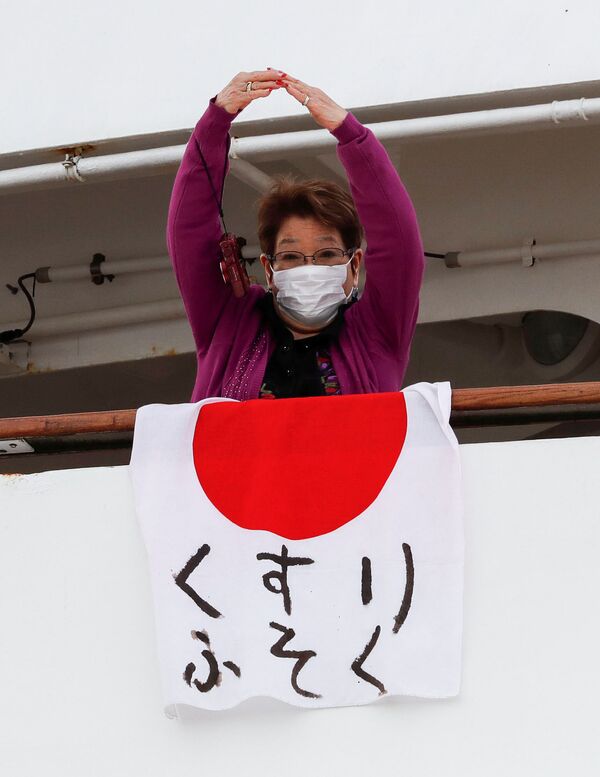 Пассажирка в медицинской маске на борту круизного лайнера Diamond Princes, помещенного в карантин у японского порта Йокогама - Sputnik Латвия