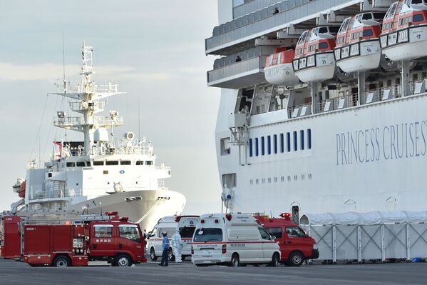 Пожарные машины и кареты скорой помощи у круизного лайнера Diamond Princes, помещенного в карантин у японского порта Йокогама - Sputnik Латвия