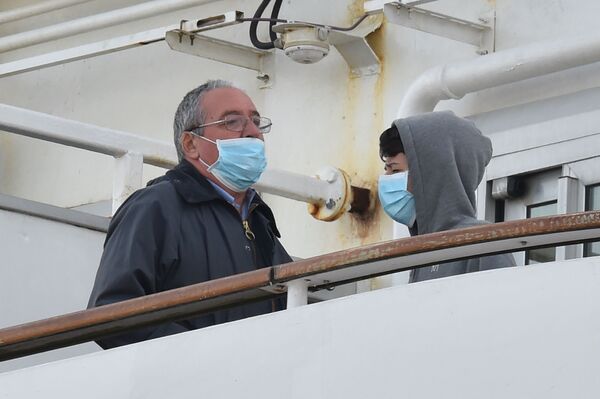 Пассажиры в медицинских масках на борту круизного лайнера Diamond Princes, помещенного в карантин у японского порта Йокогама - Sputnik Латвия