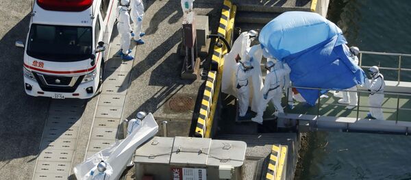 Сотрудники полиции в защитных костюмах помещают в машину скорой помощи заболевшего пассажира круизного лайнера Diamond Princes, помещенного в карантин у японского порта Йокогама Сотрудники полиции в защитных костюмах помещают в машину скорой помощи заболевшего пассажира круизного лайнера Diamond Princes, помещенного в карантин у японского порта Йокогама - Sputnik Латвия