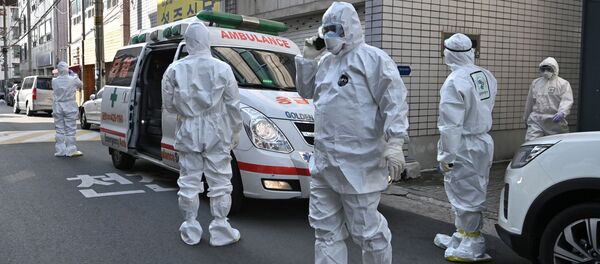 Медицинские работники, одетые в защитные костюмы Медицинские работники, одетые в защитные костюмы - Sputnik Latvija
