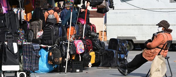 Человек в защитной маске сидит на рынке Человек в защитной маске сидит на рынке - Sputnik Latvija