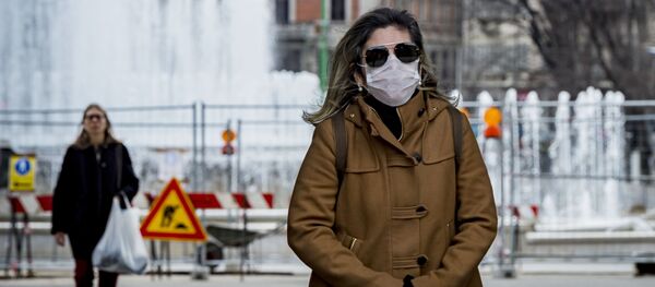 Женщина в медицинской маске в центре Милана Женщина в медицинской маске в центре Милана - Sputnik Latvija