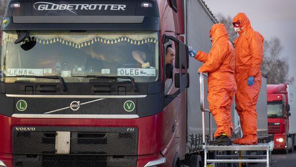 Медицинские сотрудникие осматривают пересекающих польскую границу водителей - Sputnik Латвия
