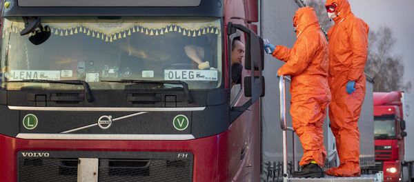 Медицинские сотрудникие осматривают пересекающих польскую границу водителей - Sputnik Латвия