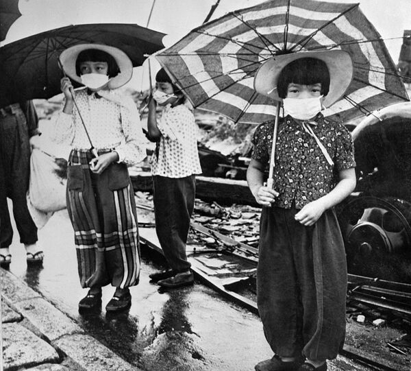Дети в масках для защиты от облучения в разрушенной бомбардировкой Хиросиме, Япония, 1948 год - Sputnik Латвия