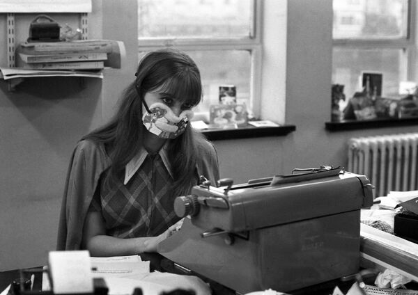 Секретарша в защитной маске в одном из лондонских офисов во время эпидемии гриппа, 1970 год - Sputnik Латвия