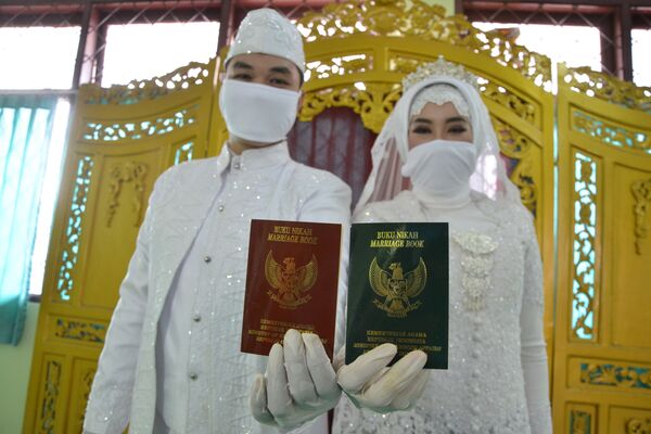 Молодожены со свадебными сертификатами в Джакарте  - Sputnik Латвия