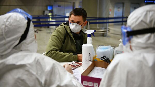 Медицинские работники во время проверки состояния пассажира в аэропорту Внуково - Sputnik Latvija