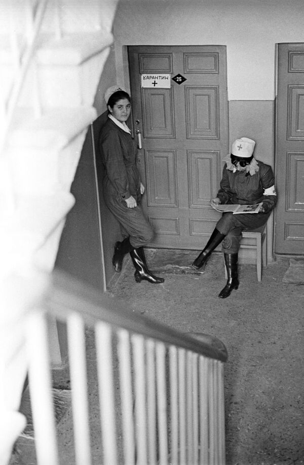 Санитарные работники несут дежурство у дверей квартиры, жильцы которой проходят курс лечения от холеры, 1971 год - Sputnik Латвия