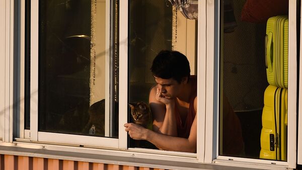 Молодой человек с кошкой на балконе многоквартирного дома в Москве - Sputnik Latvija