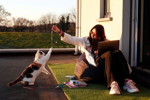 Девушка играет с кошкой на пороге своего дома в бельгийской деревне - Sputnik Латвия