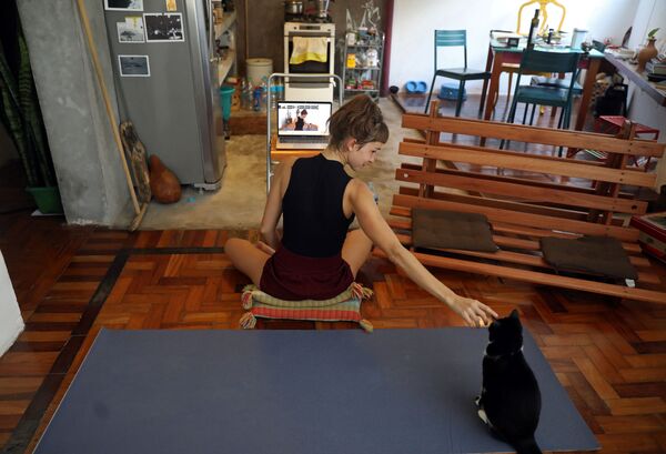 Инструктор по йоге со своей кошкой во время онлайн-урока у себя дома в Рио-де-Жанейро, Бразилия - Sputnik Латвия
