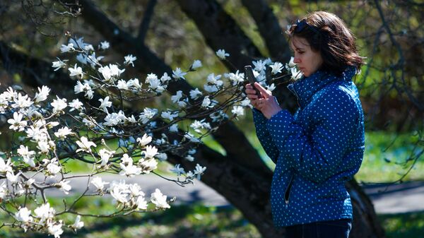 Девушка рядом с цветущей магнолией - Sputnik Латвия