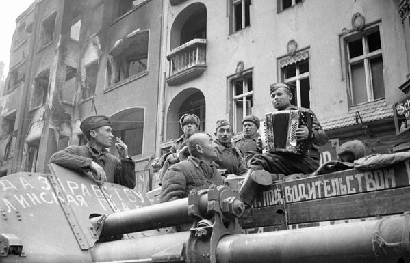 Двадцатого апреля огнем дальнобойной артиллерии 1-го Белорусского фронта по Берлину было положено начало его штурму. На фото - советские солдаты слушают баян на улицах Берлина  - Sputnik Латвия