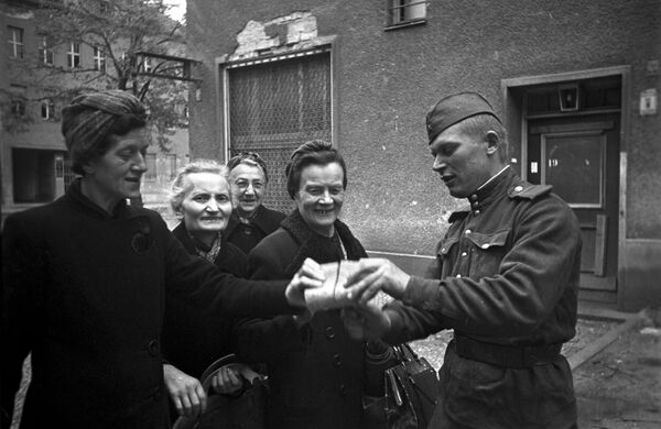 Советский солдат раздает хлеб женщинам в Берлине, 7 мая 1945 года - Sputnik Латвия