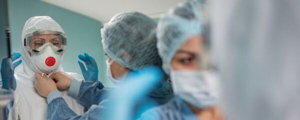 Медицинские работники надевают защитные костюмы и маски для работы с больными с коронавирусной инфекцией Медицинские работники надевают защитные костюмы и маски для работы с больными с коронавирусной инфекцией - Sputnik Latvija