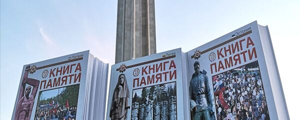 Книга памяти на фоне памятника Освободителям Риги. - Sputnik Латвия