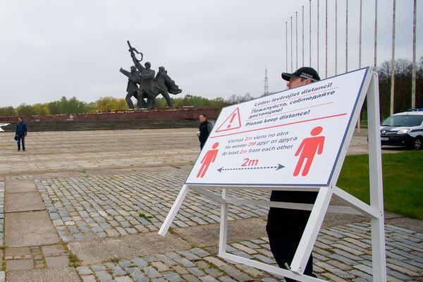 Плакат у памятника Освободителям, напоминающий о необходимости соблюдать социальную дистанцию - Sputnik Латвия