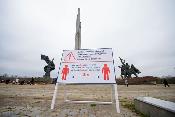 Плакат у памятника Освободителям, напоминающий о необходимости соблюдать социальную дистанцию - Sputnik Латвия