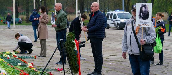 Елизавета Кривцова, Владимир Соколов и Иосиф Корен у памятника Освободителям с портретами родственников-ветеранов Елизавета Кривцова, Владимир Соколов и Иосиф Корен у памятника Освободителям с портретами родственников-ветеранов - Sputnik Latvija