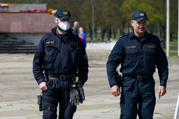День Победы у памятника Освободителям в Риге. Полицейский в маске - Sputnik Латвия