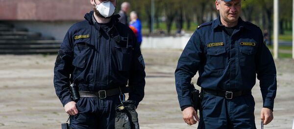 День Победы у памятника Освободителям в Риге. Полицейский в маске - Sputnik Латвия