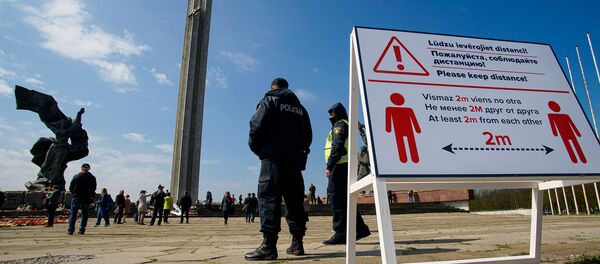 День Победы у памятника Освободителям в Риге. Плакат напоминает о социальной дистанции. - Sputnik Латвия
