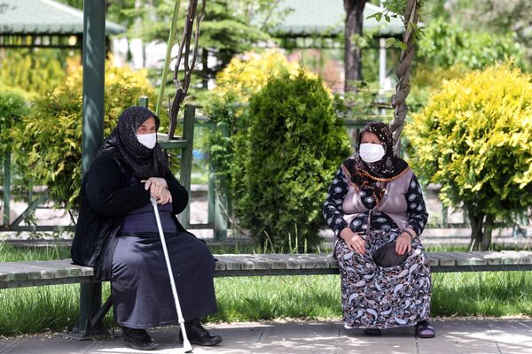 Пожилые женщины в медицинских масках на скамейке в одном из парков Анкары, Турция - Sputnik Латвия