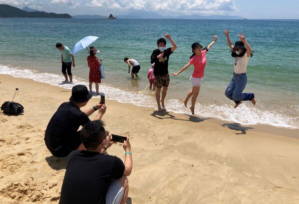 Люди в масках на пляже во время фотогарфирования в Китае  - Sputnik Латвия