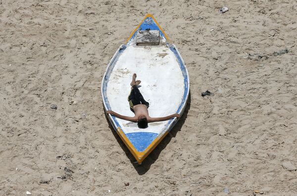 Палестинский юноша во время отдыха на пляже в Газе  - Sputnik Латвия