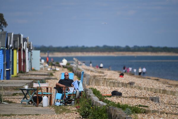 Мужчина во время отдыха на пляже в Южной Англии  - Sputnik Латвия