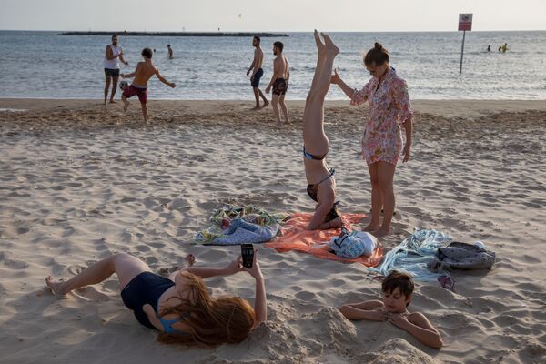 Люди во время отдыха на пляже в Тель-Авиве  - Sputnik Латвия