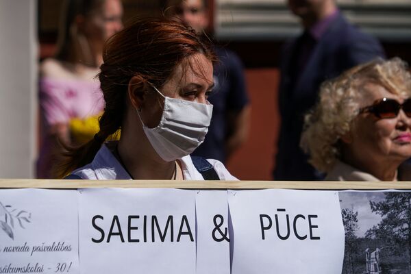 Униженная и разделенная Латвия: зачем люди с плакатами собрались у здания Сейма - Sputnik Латвия