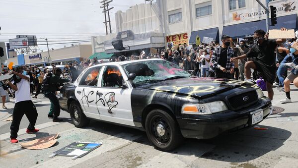 Протестующие в Лос-Анджелесе разбивают полицейский автомобиль - Sputnik Latvija