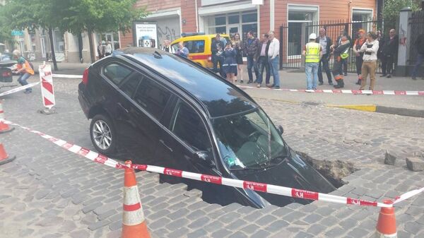 Автомобиль провалился в яму на улице Гертрудес - Sputnik Латвия