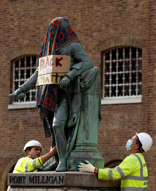  Рабочие убирают статую Роберта Миллигана, накрытую одеялом и с надписью Black Lives Matter, Лондон, Великобритания. - Sputnik Латвия