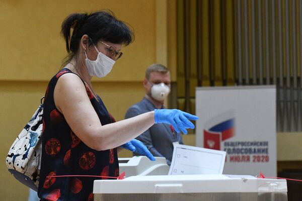 Женщина голосует по одобрению внесения поправок в Конституцию РФ на избирательном участке № 145 в Москве - Sputnik Латвия