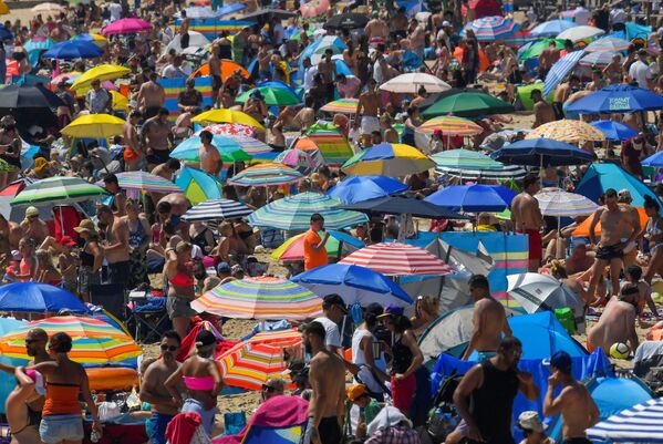 Люди наслаждаются жаркой погодой на пляже в Борнмуте, Великобритания - Sputnik Латвия