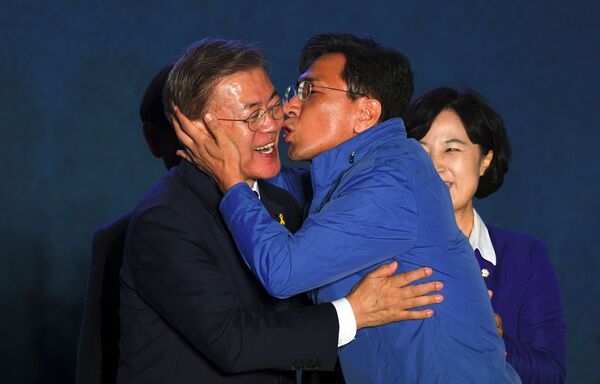 Кандидат в президенты Мун Чжэ Ин во время поцелуя однопартийца в Сеуле  - Sputnik Латвия