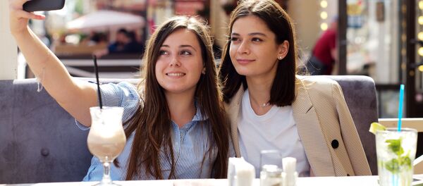 Девушки в летнем кафе на улице Старый Арбат после снятия карантина в Москве - Sputnik Латвия