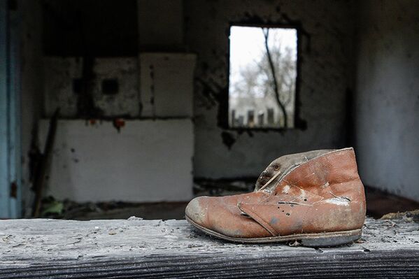 Детский ботинок на подоконнике дома деревни Ломачи, отселенной в 1990-1991 годах - Sputnik Латвия
