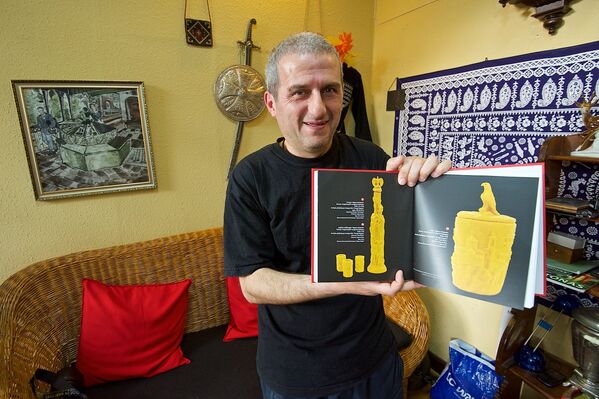 Malhazs Eremašvili demonstrē albumu ar savu darbu paraugiem. - Sputnik Latvija