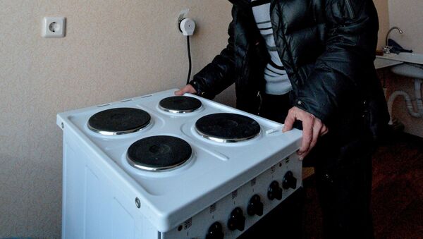 Мужчина осматривает электрическую плиту. Архивное фото - Sputnik Латвия