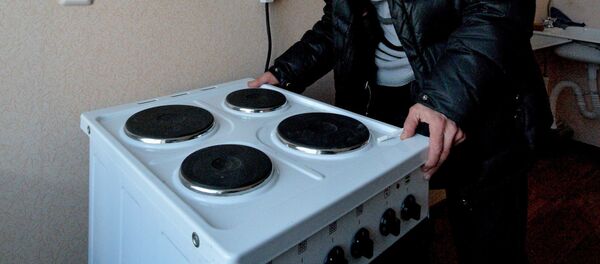 Мужчина осматривает электрическую плиту. Архивное фото - Sputnik Латвия
