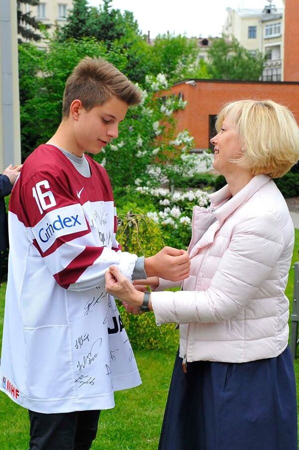 Посол Латвийской Республики Астра Курме примеряет на сына майку сборной с автографами хоккеистов - Sputnik Латвия