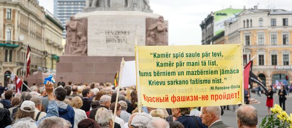 Надпись на плакате - Пока тебе светит солнце, пока мне льёт дождик. Нам нужно учить наших детей и внуков, русский красный фашизм не пройдёт - Sputnik Latvija