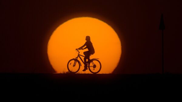 Девушка катается на велосипеде на закате - Sputnik Латвия